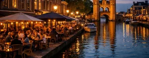 Drukke terrassen langs de gracht bij de Waterpoort in Sneek in de avondschemering.